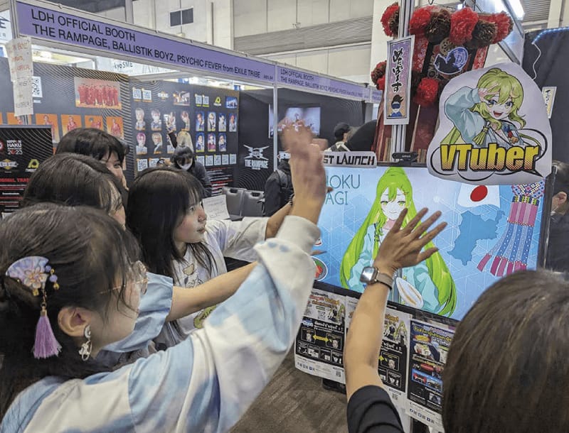 イベントブースでAIアバターと交流する来場者