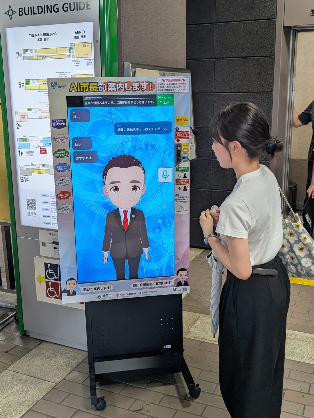 盛岡市役所でAIアバターの案内端末を利用する来庁者